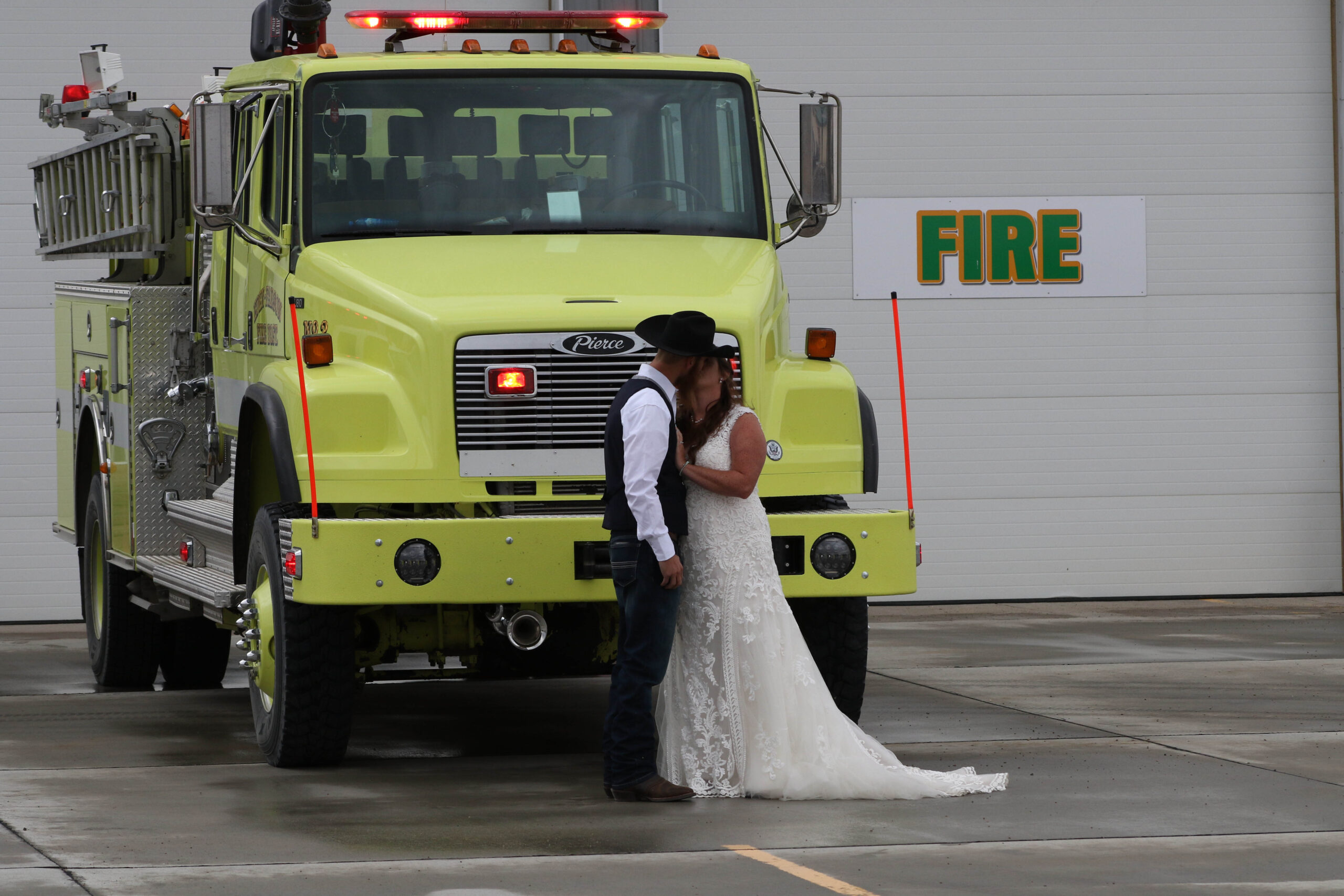 Photo of bride and groom in front of fire truck